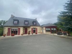 Una casa grande con una entrada para autos en frente de ella en Chambres du Vau-Nogues, en Pleudihen-sur-Rance