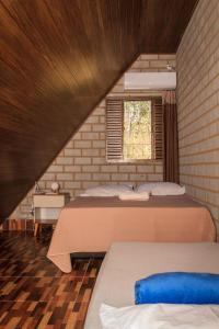um quarto no sótão com 2 camas e uma janela em Chale elegante c hidromassagem no Alto Paraiso GO em São Jorge
