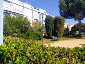 a park with a bench in front of a building at ALAMANDA STUDIO LE GRAU DU ROI - in Le Grau-du-Roi