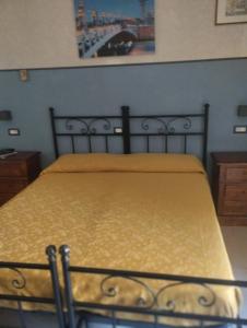 a bedroom with a bed with a yellow blanket at Hotel Ristorante Stella in Palestrina