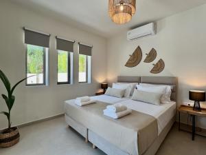 a bedroom with a large bed with towels on it at Villa Karissa in Gavalochori +56 photos