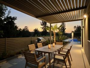 a patio with a table and chairs and a grill at Villa Karissa in Gavalochori