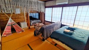 1 dormitorio con 1 cama y 1 hamaca en una habitación en Ryokan La Luna, en Izu