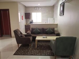 a living room with a couch and a coffee table at راما للاجنحة الفندقية in Jeddah