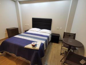 Un dormitorio con una cama y una mesa con un tazón. en Hotel Sol de Marcona, en San Juan