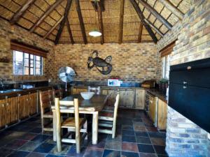a kitchen with a table and chairs and a brick wall at Mokuru Private Nature Reserve in Brits