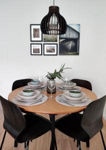a dining room table with chairs and aendant light at Trendy apartment in the heart of green Lahti, free parking in Lahti