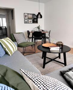 a living room with a couch and a table and chairs at Trendy apartment in the heart of green Lahti, free parking in Lahti