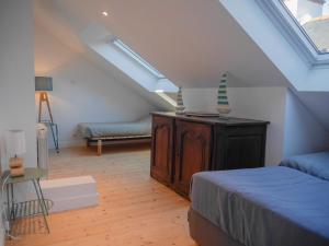 a room with a bed and a couch in a attic at Maison Sauzon, 5 pièces, 8 personnes - FR-1-418-201 in Sauzon