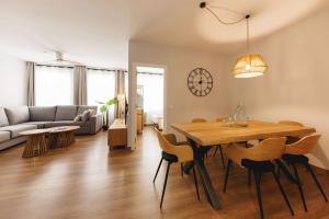 a living room with a table and chairs and a couch at Bravissimo Figuerola, Spacious 3-bedroom apartment in Girona