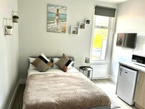 a white bedroom with a bed and a window at Southall Stays near Heathrow UB2 in Southall