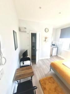 a living room with a bed and a table and chairs at Southall Stays near Heathrow UB2 in Southall