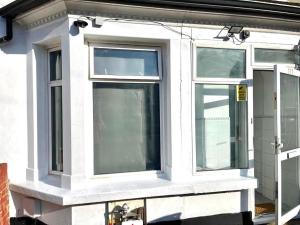 three windows on the side of a house at Southall Stays near Heathrow UB2 in Southall