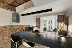 a living room with a black counter and chairs at BCN Town Apartments Portaferrissa in Barcelona
