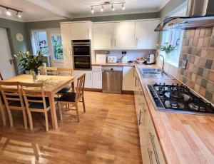 a kitchen with a wooden table and a wooden floor at Meadow View in Sidmouth