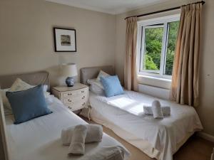 two twin beds in a room with a window at Meadow View in Sidmouth
