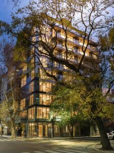 un edificio alto con un árbol delante de él en Casa Joseph en Buenos Aires