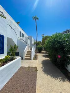 un edificio con scale e una palma sullo sfondo di Los Barqueros 24 by Best Holidays Fuerteventura a Corralejo