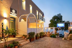 un edificio con un patio delante de él en Captain's House Hotel Suites & Apartments en Panormos Rethymno
