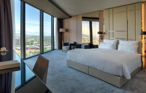 a hotel room with a bed and large windows at Grand Plaza Hotel & Congress Center in Ljubljana +37 photos