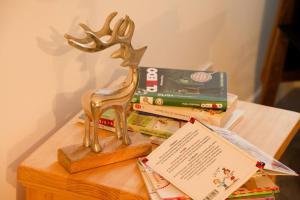 una statua di una renna seduta su un tavolo con dei libri di La Thorésienne a Thorée-les-Pins