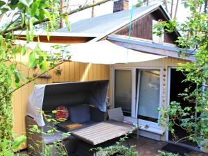 eine abgeschirmte Veranda mit einer Bank und einem Haus in der Unterkunft Ferienhaus Lubmin VORP 2441 in Lubmin