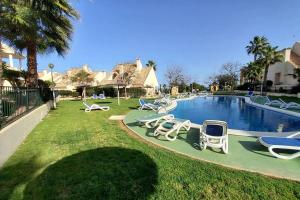 una piscina con sedie a sdraio in un cortile di Superbe appartement calme vue mer a Orihuela Costa