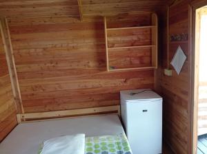 ASTRA Lančov في Lančov: غرفة صغيرة مع ثلاجة في جدار خشبي