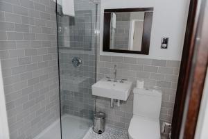 a bathroom with a toilet and a sink and a shower at Woodlands Hotel in Leeds