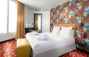 パリにあるリベルテル カナル サン マルタンの花柄の壁紙を用いたベッドルーム1室(白い大型ベッド1台付)