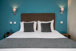 1 dormitorio con 1 cama grande y pared azul en Rising Sun Hotel by Greene King Inns en Cheltenham