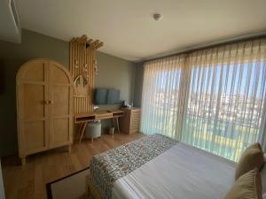 a bedroom with a bed and a desk and a window at La Terrazza Hotel in Famagusta