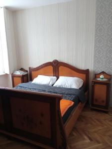 um quarto com uma cama de madeira e 2 mesas de cabeceira em Apartment DREAMS em Sombor