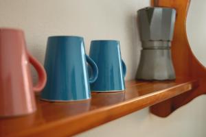 three blue mugs sitting on a wooden shelf at Batán de las Monjas in San Nicolás del Puerto