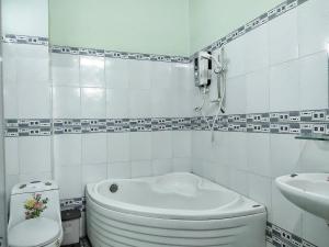 Baño blanco con aseo y lavamanos en Nhà nghỉ Kim Vân, en Soc Trang