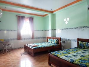 朔莊的住宿－Nhà nghỉ Kim Vân，客房设有两张床和一扇窗户。