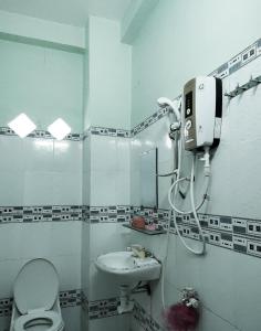 y baño con aseo, lavabo y espejo. en Nhà nghỉ Kim Vân, en Soc Trang