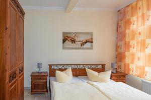 a bedroom with a white bed with two pillows at WassermannApartments in Burg