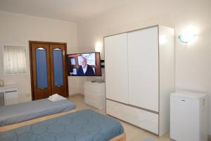 a bedroom with a bed and a flat screen tv at Room in Guest room - Emilios home Triple room in our cozy and comfortable establishment in Rome
