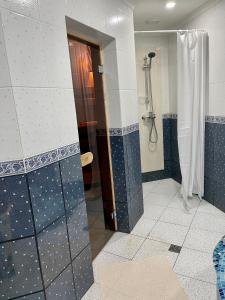 a bathroom with a shower with blue tiles at Bukovynskiy Zatyshok Chalet in Bukovel