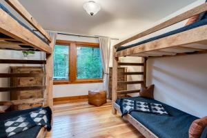 two bunk beds in a room with wooden floors at Tamanawas Cabin in Rhododendron