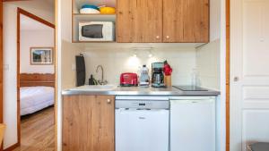 a small kitchen with a sink and a microwave at V DU BACHAT - Silene D11 in Chamrousse