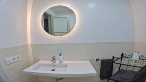 een badkamer met een witte wastafel en een spiegel bij Apartamento Tierra, Primera línea Mar in Playa Honda +21 foto's