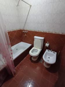 a bathroom with a toilet and a sink and a tub at Casa familiar in Corrientes