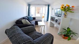 een woonkamer met een bank en een tv bij Apartamento Tierra, Primera línea Mar in Playa Honda