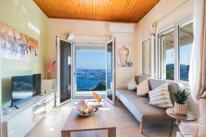 a living room with a couch and a tv at Corfu sight Blue in Spartýlas