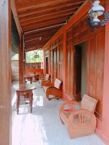 a porch with benches and tables on a house at Rumah Ukhi in Yogyakarta