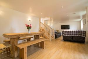 un salon avec une table en bois et un canapé dans l'établissement Hendra Retreat Piglets Cottage North Cornwall, à Camelford