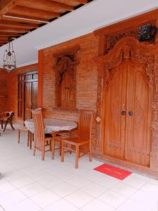 a dining room with a table and chairs and a brick wall at Rumah Ukhi in Yogyakarta