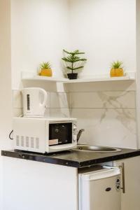 a microwave sitting on top of a counter in a kitchen at UB2 Suites - Heathrow London in Southall